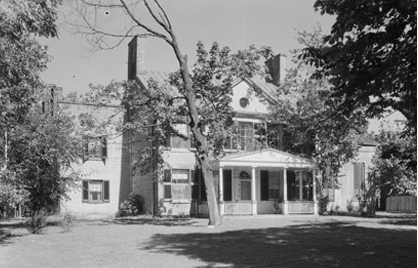 1800's style home surrounded by trees